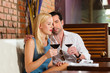 Attractive couple drinking red wine in restaurant or bar