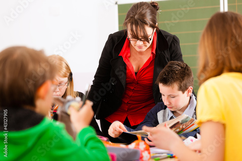 Foto: Schulkinder und Lehrerin lernen an der Schule Schulkinder und Lehrerin lernen an der Schule