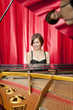 Pretty young woman playing a grand piano