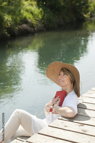 Photo: Woman reading by the river Woman reading by the river