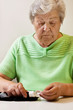 Foto: Seniorin nimmt sich Teststreifen für das Messen des Blutzuckers Seniorin nimmt sich Teststreifen für das Messen des Blutzuckers