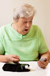 Foto: Seniorin beim Blutzucker messen ist von den Werten überrascht Seniorin beim Blutzucker messen ist von den Werten überrascht