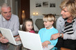 Grandparents with children and laptops