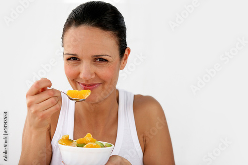 Photo: Woman eating a bowl of fruit Woman eating a bowl of fruit