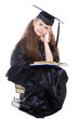 girl in black academic cap and gown reading big blue book