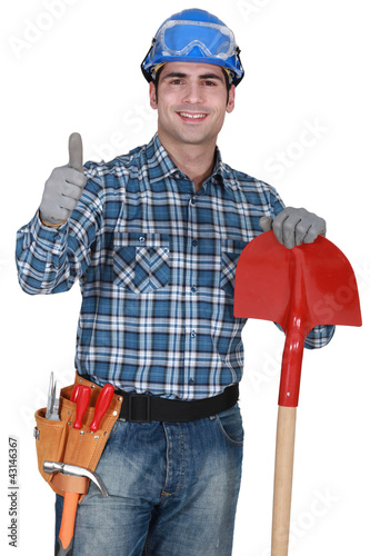 Photo: Manual worker with gloves and spade giving thumbs-up Manual worker with gloves and spade giving thumbs-up