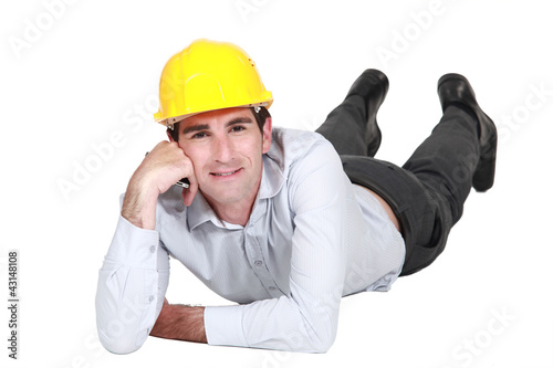 Photo: Architect laying on the floor resting Architect laying on the floor resting