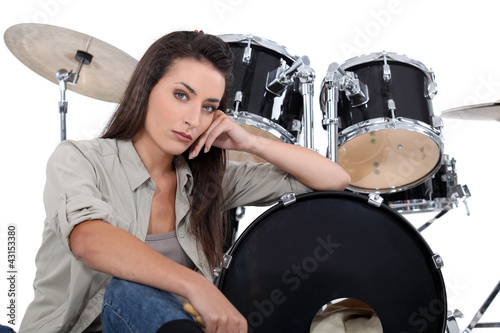 Photo: Brunette sat in front of drum kit Brunette sat in front of drum kit