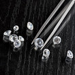 Photo: loose diamond on black surface with tweezers loose diamond on black surface with tweezers