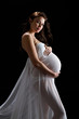 Beautiful brunette model in last trimester posing in studio