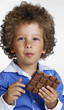 Foto: Niño sujetando una barra de chocolate,comiendo chocolate. Niño sujetando una barra de chocolate,comiendo chocolate.