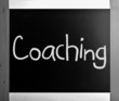 "Coaching" handwritten with white chalk on a blackboard