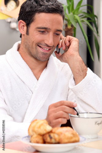 Photo: Man making a call over breakfast Man making a call over breakfast