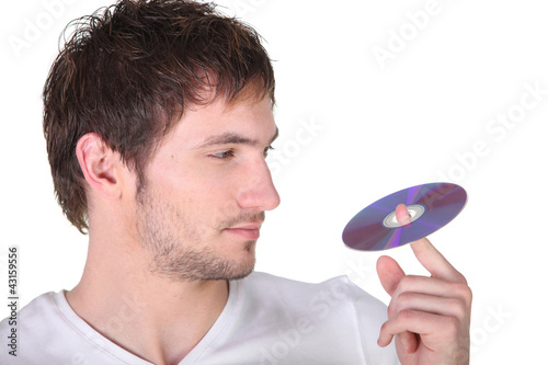 Photo: Young man spinning a digital recording disc on his finger Young man spinning a digital recording disc on his finger