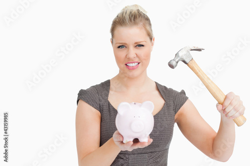 Photo: Woman want break a piggy bank with a hammer Woman want break a piggy bank with a hammer