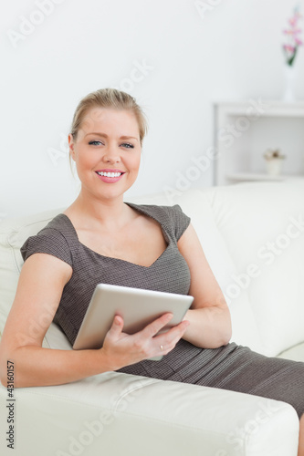 Photo: Woman smiling using a tablet pc Woman smiling using a tablet pc