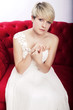 Foto: junges mädchen mit brautkleid auf rotem sofa junges mädchen mit brautkleid auf rotem sofa