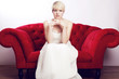 Foto: junges mädchen mit brautkleid auf rotem sofa junges mädchen mit brautkleid auf rotem sofa