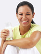 Joven mujer latina bebiendo un vaso de leche.
