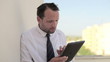 Frustrated businessman looking at tablet computer