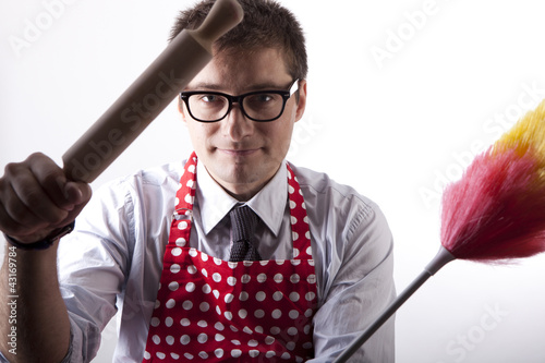 Photo: Young man with duster and kitchen tool Young man with duster and kitchen tool