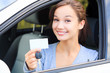 girl in a car showing a key and an empty white card