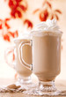 coffee latte macchiato with cream in glasses on leaves backgroun