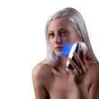 Photo: Young woman getting face phototherapy treatment by blue light Young woman getting face phototherapy treatment by blue light