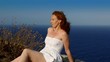 happy redhead woman  feeling wind in high cliff  sea