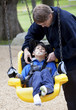 Father pushing disabled son  on handicap swing