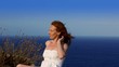 happy redhead woman  feeling wind in high cliff  sea