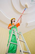 Photo: Painter worker during painting job Painter worker during painting job