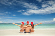 Photo: Happy friends in santa hats on the beach. Christmas vacation Happy friends in santa hats on the beach. Christmas vacation