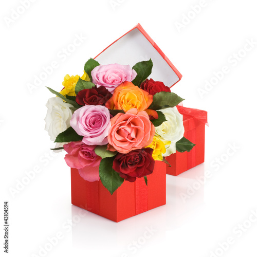 Photo: Red gift box with colorful roses on white background Red gift box with colorful roses on white background