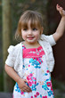 Smiling two year old girl posing outdoors in the park