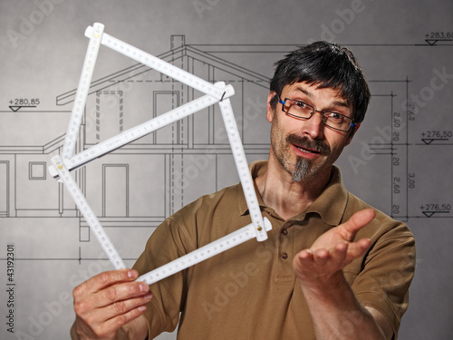 Foto: man with folding rule in the shape of a house man with folding rule in the shape of a house