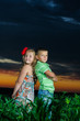 group of happy children playing on meadow, sunset, summertime