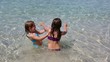 little girls playing in beach water in ibiza island