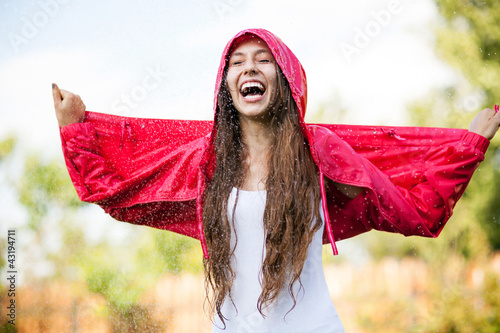 Foto: Woman in raincoat enjoying the rain Woman in raincoat enjoying the rain