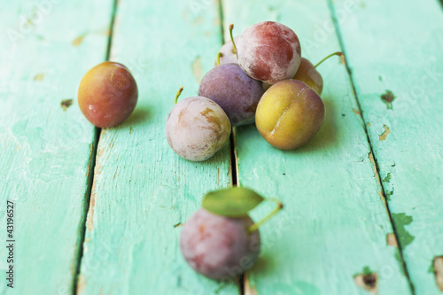 Foto: group of plums on rustic turquose surface group of plums on rustic turquose surface