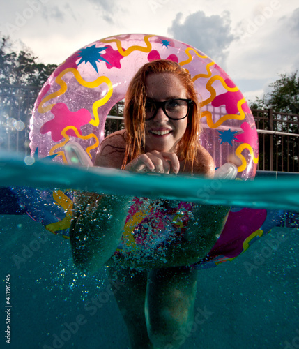 Photo: Young Woman playing and swimming in a Pool Young Woman playing and swimming in a Pool