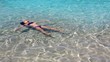 little girl playing and floating in beach water in ibiza island