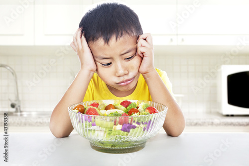 Photo: Unhappy child to eat salad Unhappy child to eat salad