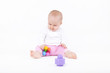 8 month old baby girl playing on the ground with her toys