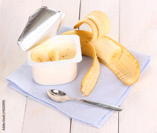 Photo: yogurt with banana on wooden background yogurt with banana on wooden background