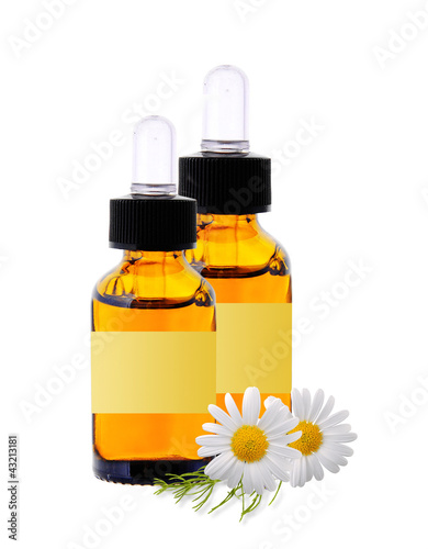Photo: bottles with essence oil and chamomiles isolated on white bottles with essence oil and chamomiles isolated on white