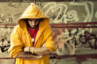 Photo: Young man in hooded sweatshirt on grunge wall Young man in hooded sweatshirt on grunge wall
