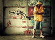 Photo: Young man in hooded sweatshirt on grunge wall Young man in hooded sweatshirt on grunge wall