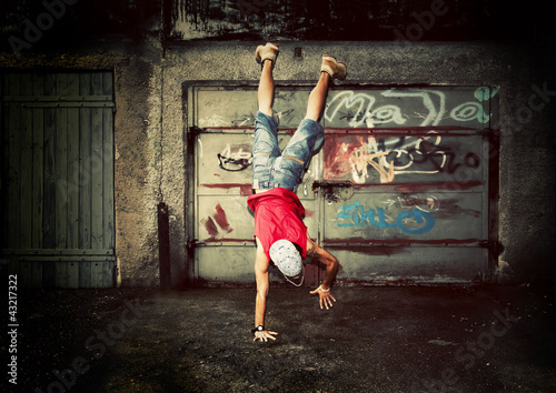 Photo: Young man dancing on grunge graffiti wall Young man dancing on grunge graffiti wall