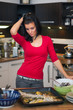 Foto: Unhappy woman standing in kitchen Unhappy woman standing in kitchen